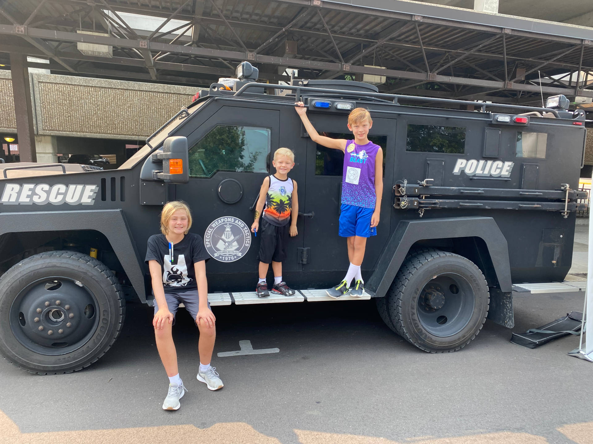 Fair participants take a break from exploring CPD’s SWAT Vehicle to pose for a photo.